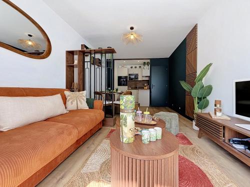 a living room with a couch and a table at L'Amour des Îles - Centre - Plage - Parking in Cabourg