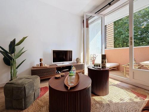 a living room with a large window and a tv at L'Amour des Îles - Centre - Plage - Parking in Cabourg