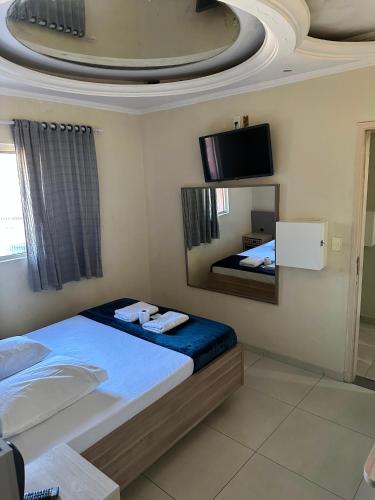 a bedroom with a bed and a tv on the ceiling at Hotel Skala - Estacionamento Próprio no Local - 1 km Parque Antônio Pezzolo e 700 métros da Estação de Trem Prefeito Saladino in São Paulo