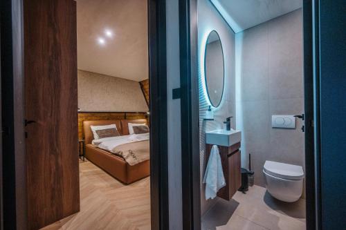 a bathroom with a bed and a toilet and a mirror at The Frame Croatia in Ravna Gora