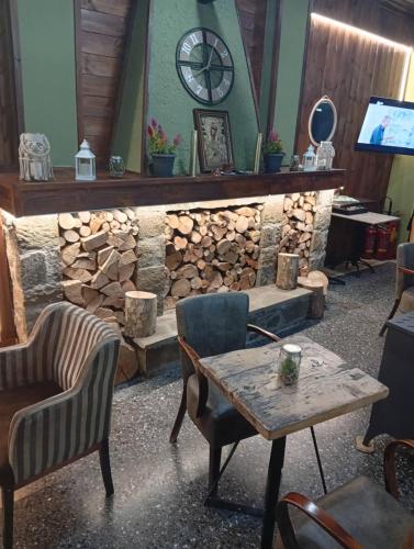 a room with a stone fireplace with a table and chairs at FANTINO HOTEL in Domnista