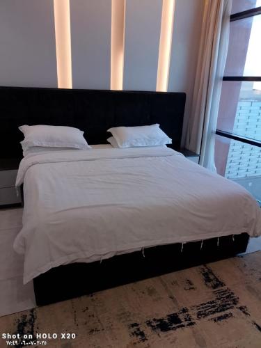 a bed with white sheets and pillows in a bedroom at BELLA ViTA in Jeddah