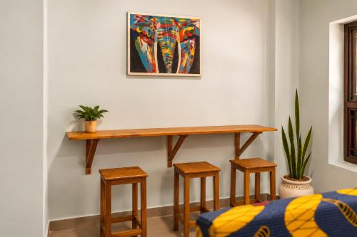 a table and stools in a room with a painting at Cozy Quarters in Zanzibar City