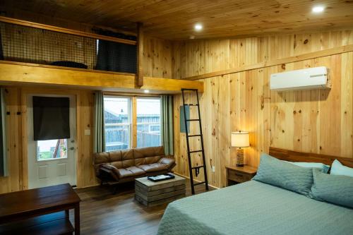 a bedroom with wooden walls and a bed and a couch at Ye Olde Argyler Lodge in Pubnico