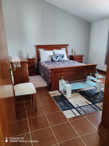 a bedroom with a bed and a chair in it at Villa Luisa Torres in Argozelo