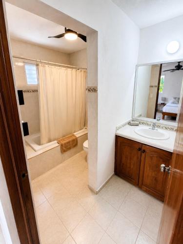 a bathroom with a sink and a toilet and a mirror at Aguacatl Cozumel a 3 cuadras del mar in Cozumel
