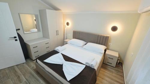 a bedroom with a large bed and a mirror at Pateriku Apartments in Shkodër