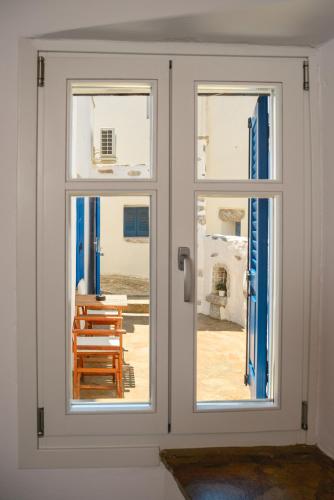 two windows in a room with a table and chairs at Omnia Apartments Amorgos No2 in Amorgos