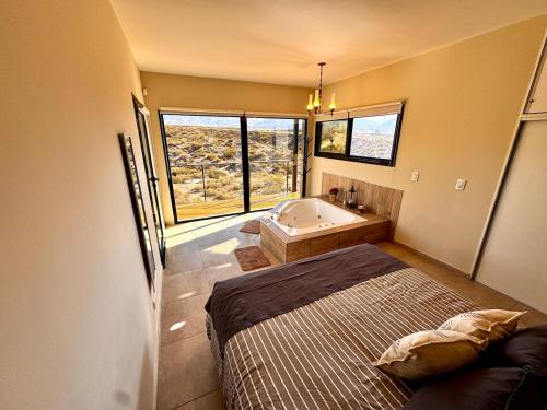 a bedroom with a bed and a bath tub at Villamagna, cabaña con jacuzzi en Potrerillos in Potrerillos