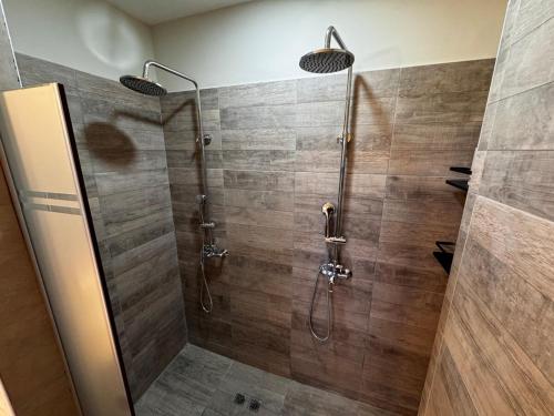 a shower with a glass door in a bathroom at Villamagna, cabaña con jacuzzi en Potrerillos in Potrerillos