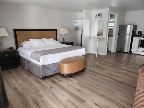 a bedroom with a large bed and wooden floors at The Lake Huron Resort in Oscoda