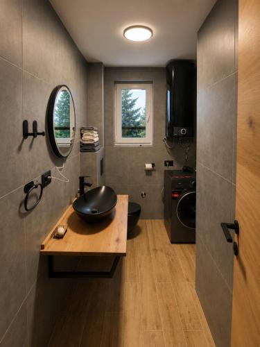 a bathroom with a sink and a washing machine at Peak Vista A-Frame in Sarajevo