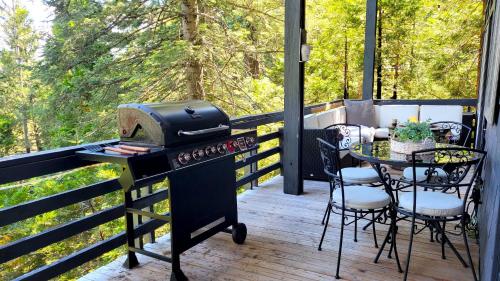 a grill on a screened in porch with a table and chairs at Cielo Ridge in Twin Peaks