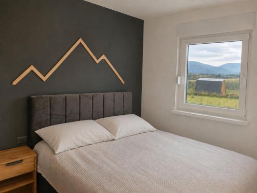 a bed in a bedroom with a chart on the wall at Peak Vista A-Frame in Sarajevo