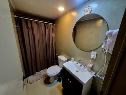 a bathroom with a toilet and a sink and a mirror at Villa Lainez in Villa Mercedes