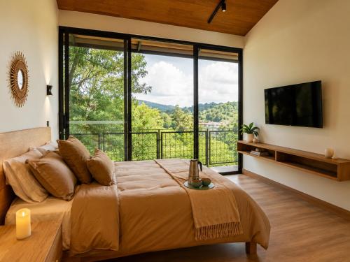 a bedroom with a large bed with a large window at Verso el Retiro in El Retiro