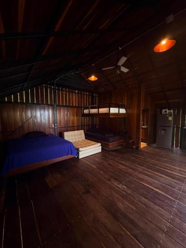 a bedroom with a bed and a wooden floor at AJ EcoGlamping in Santo Domingo