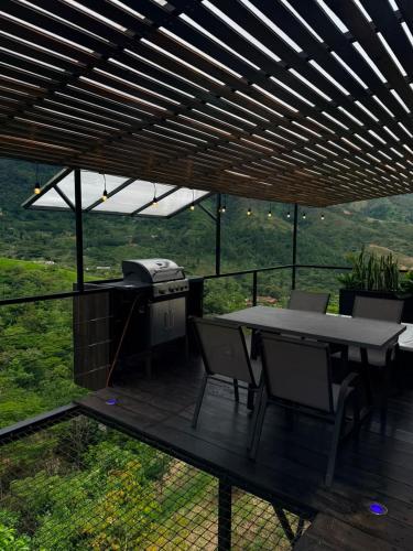 a patio with a grill and a table and chairs at AJ EcoGlamping in Santo Domingo