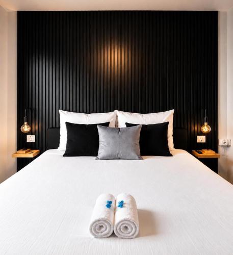 a bedroom with a bed with two slippers on it at Charleroi Brussels Airport White Castle in Charleroi