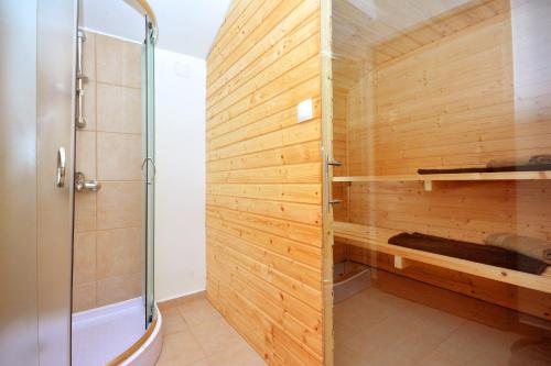 a shower in a bathroom with a wooden wall at Holiday house with a swimming pool Basina, Hvar - 8731 in Vrbanj