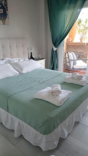 a bedroom with a bed with towels on it at Private Room Shared Apartment Sea View Pool Marbella Mijas in Sitio de Calahonda