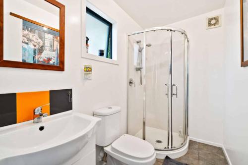 a bathroom with a shower and a toilet and a sink at Pickmere Oasis in Kerikeri