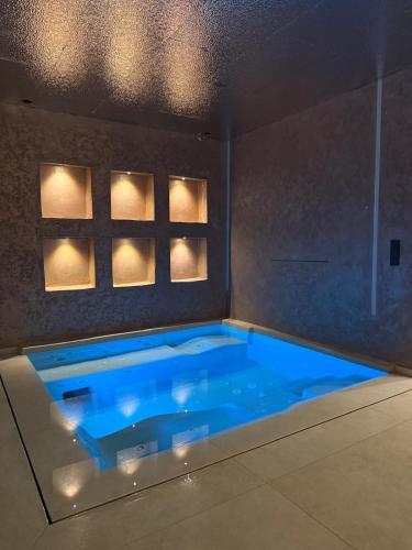 a large blue swimming pool in a room with lights at Villa élite in Tangier
