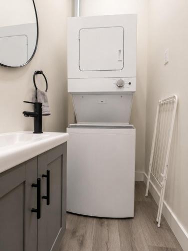 a bathroom with a washer and dryer next to a sink at The Post Hotel in Renfrew