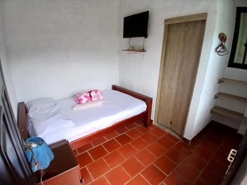 a small room with a bed and a television at Hospedaje Campestre Villa Niny in San Gil