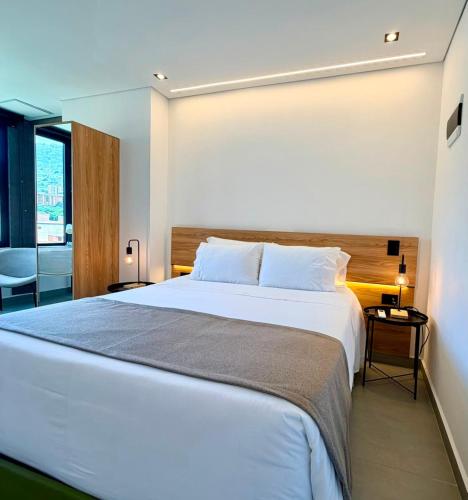 a bedroom with a large white bed and a window at Once Suites in Envigado