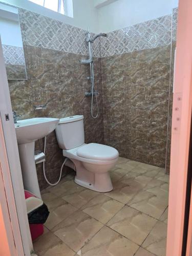 a bathroom with a toilet and a sink and a shower at Kandy City View Apartments in Kandy