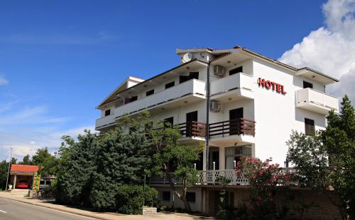 a white building with a hotel sign on it at Hotel Rajna in Starigrad-Paklenica