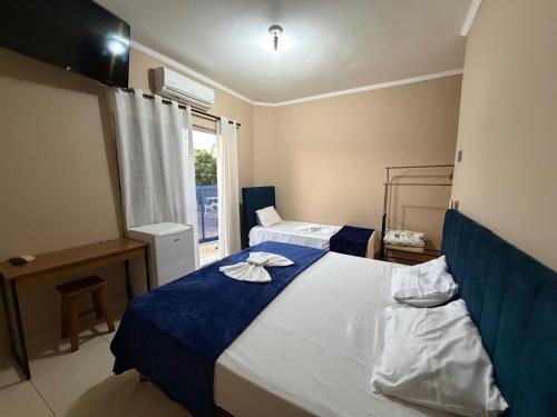 a bedroom with two beds and a window at Point Hotel in Tanabi