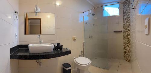 a bathroom with a sink and a toilet and a shower at Point Hotel in Tanabi