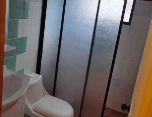 a bathroom with a white toilet and a sink at Hospedaje Francesco in Puerto Montt