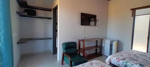 a bedroom with a green chair and a bed and a desk at Cacique Room 2 in Playa Hermosa