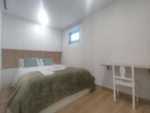 ein Schlafzimmer mit Bett, Schreibtisch und Fenster in der Unterkunft Barcelos Habadia Espigueiro in Lijó