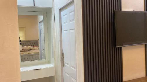 a white door with a mirror in a room at Zemira Apartments in Abuja