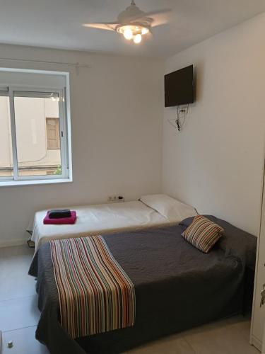 a bedroom with a bed and a flat screen tv at El Hostalito in Ontinyent