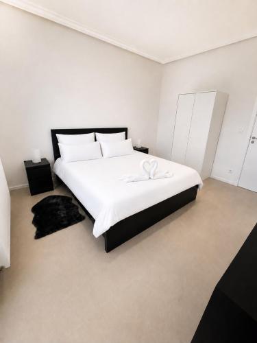 a white bedroom with a large white bed with white sheets at Spacious Apartment 1BR with Sofa bed near Atomium, Expo 12 and ING Arena in Wemmel