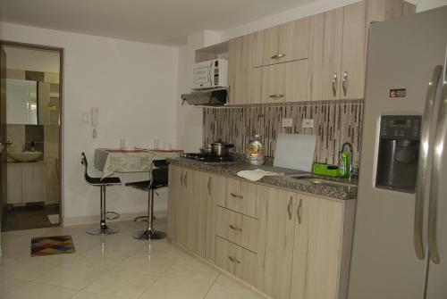 a kitchen with a refrigerator and a counter top at Comfortable Itagüí Stay in Itagüí