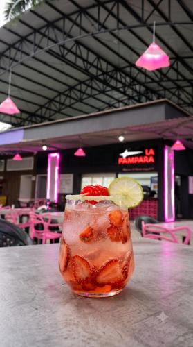 a drink on a table with a lemon and strawberries at Hotel Porton De Oriente in Puerto Triunfo