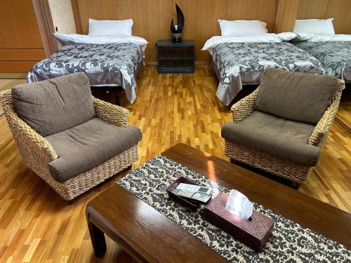 a living room with two beds and two chairs and a table at Cool-Villa 飛騨リゾート in Hida