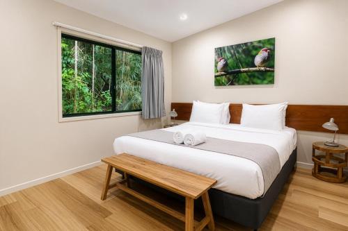 a bedroom with a large bed and a window at Chambers Wildlife Rainforest Lodges in Lake Eacham