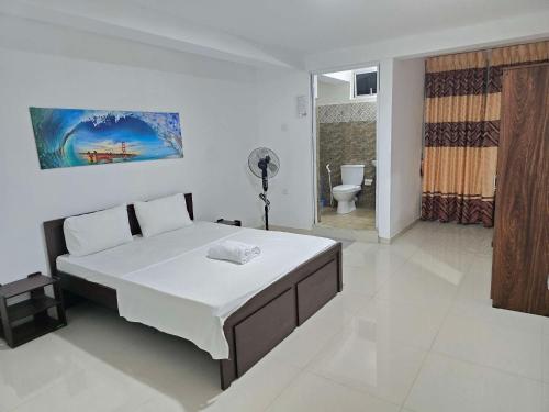 a bedroom with a large bed and a bathroom at Kandy City View Apartments in Kandy