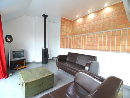 a living room with a couch and a tv at Stylish Duplex with Sauna in Modave