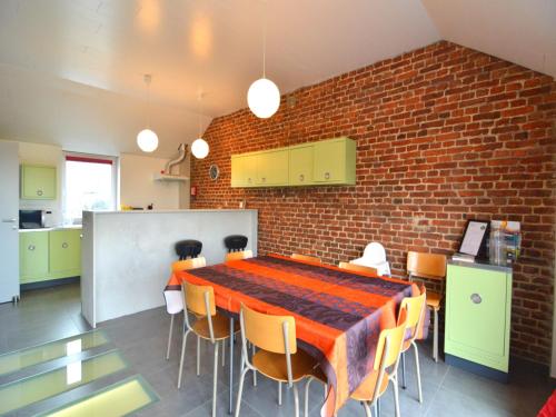 a dining room with a table and a brick wall at Stylish Duplex with Sauna in Modave