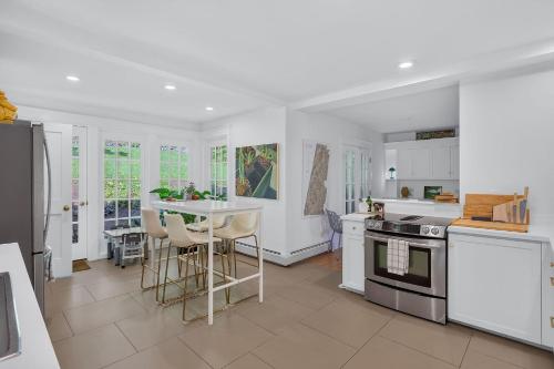 a kitchen with white appliances and a table with chairs at Classic Stockbridge Cottage in Stockbridge