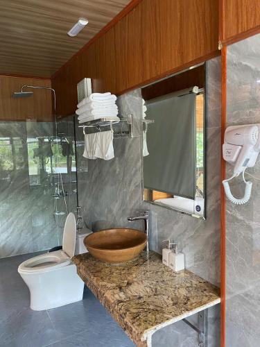 a bathroom with a wooden sink and a toilet at Xuan Son Lakeside Bungalow in Ninh Binh