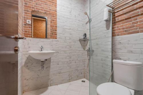 a bathroom with a toilet and a sink at RedDoorz Plus @ Doorman Guest House in Bandung